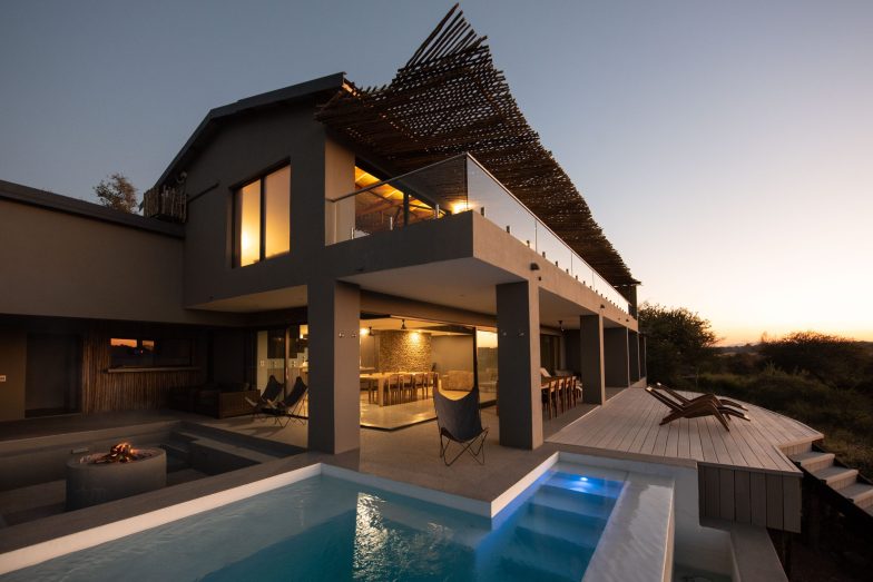 Sweeping modern villa at sunset with L shaped pool