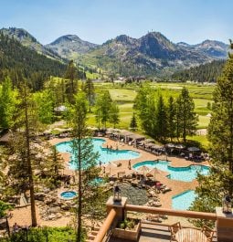 view of pools through trees with mountains in background