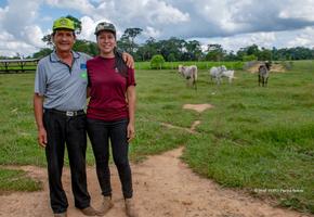 Photo of two farmers in a field with cattle 