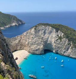 Overlooking a white sandy beach that's framed by cliffs and edged by electric blue water