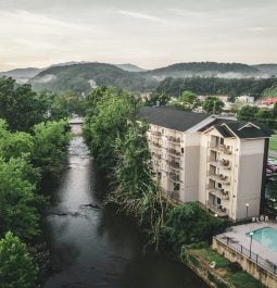 Aerial view of a hotel with a pool next to the river