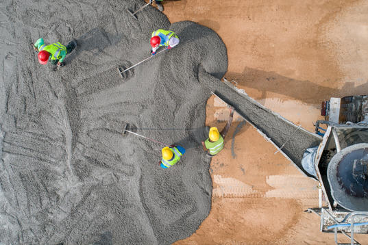 Concrete being poured by construction workers