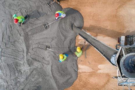 Concrete being poured by construction workers