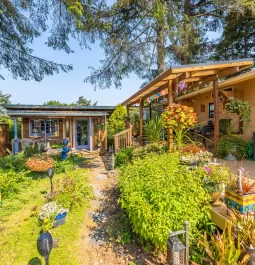 Artsy house with landscaping and raised deck